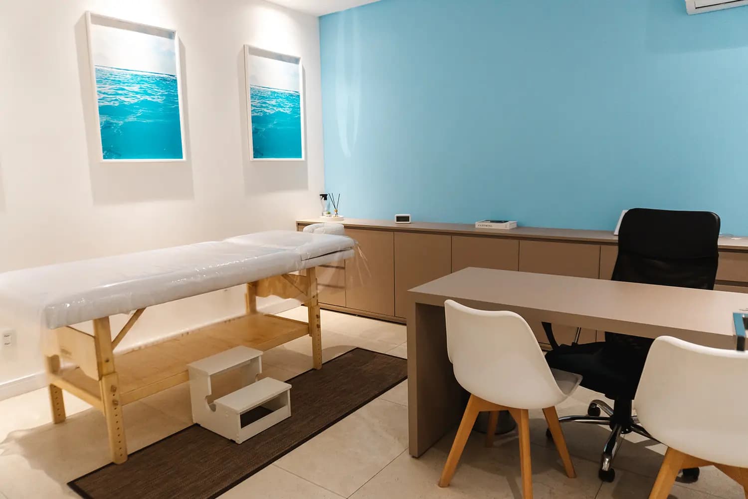 Consultório com poltronas, decoração em tons neutros e iluminação suave