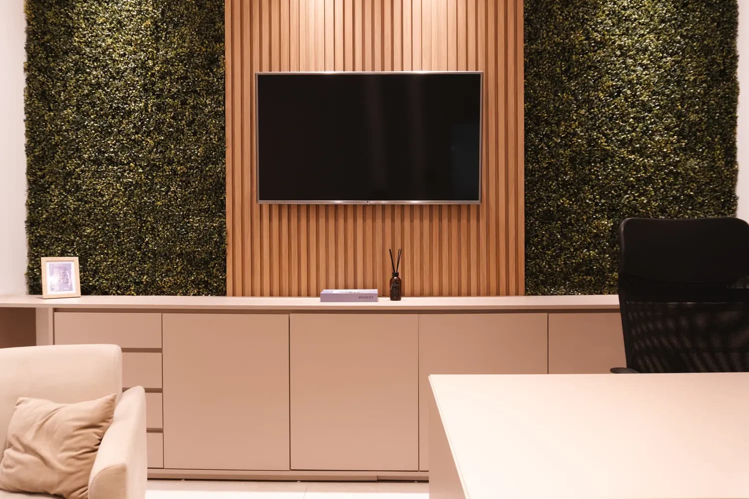 Sala Estaleiro: parede de jardim vertical, divã, poltronas e televisão, com iluminação dimerizada, ideal para psicologia e terapias